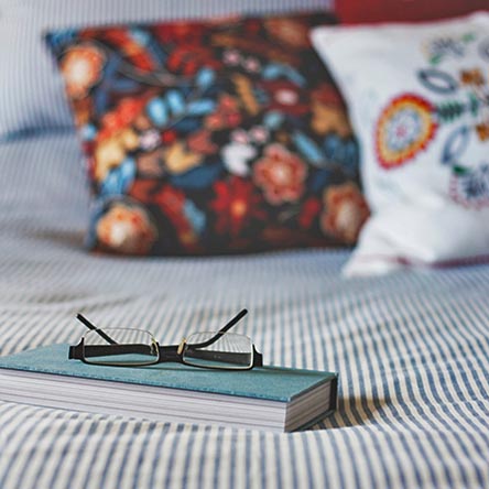 book-and-glasses-on-bed