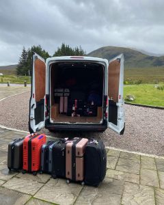 Van with open back doors and luggage in front